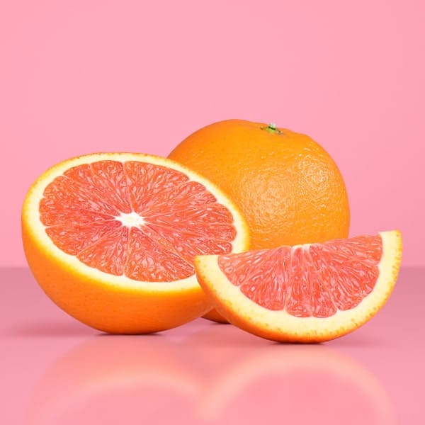 One full Cara Cara orange, a sliced in two one and a wedge another one on pink backgorund