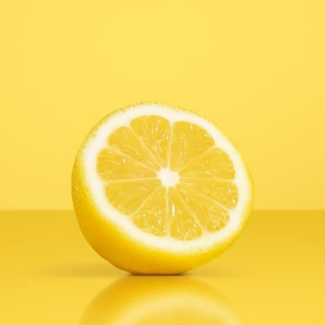 A lemon sliced in two on a yellow background